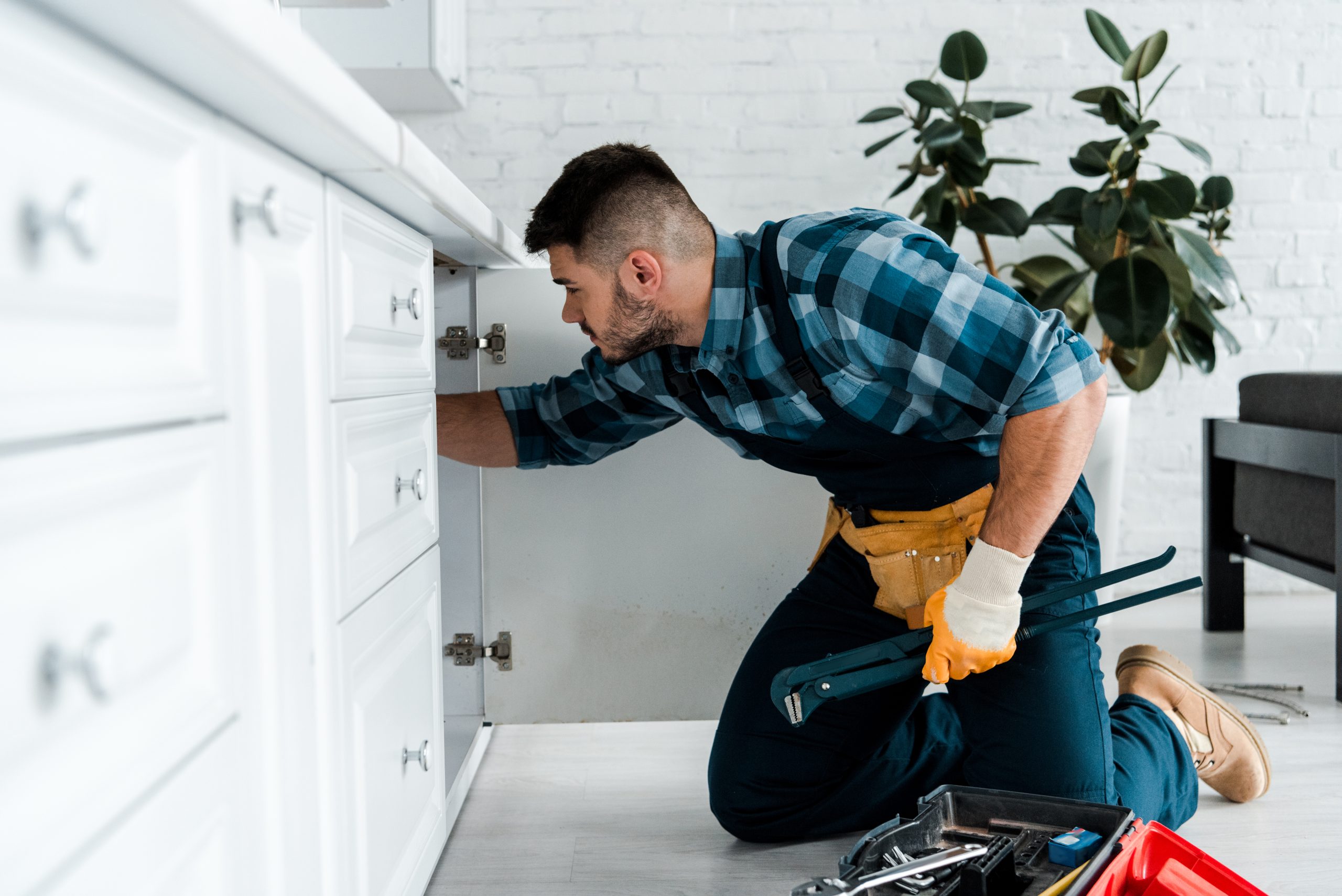 selective focus of bearded man working in kitchen near toolbox with instruments